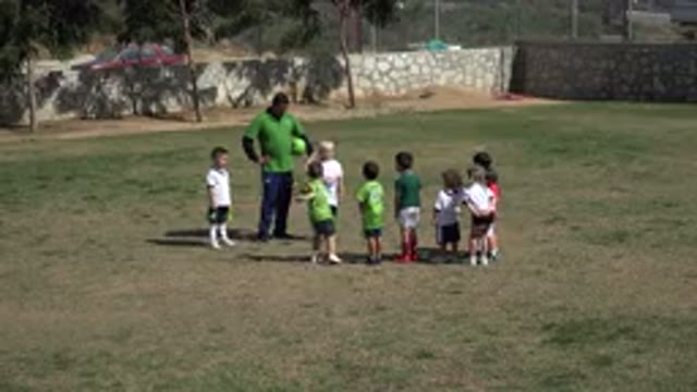 LOS CABOS MEXICO-2019: Child Soccer Players Stand Around A Coach Holding A Ball
