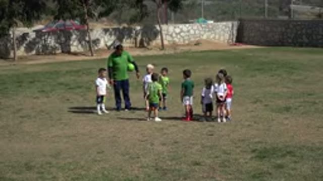 LOS CABOS MEXICO-2019: Man Wearing Green Shirt Holds Green Ball While Talking To Group