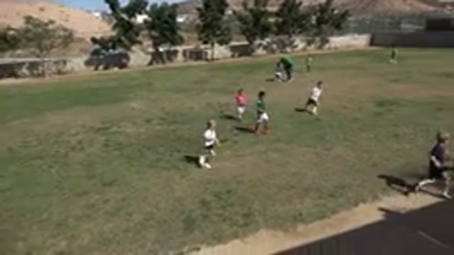 LOS CABOS MEXICO-2019: Kids Running On A Grassy Field Chasing After A Green Ball