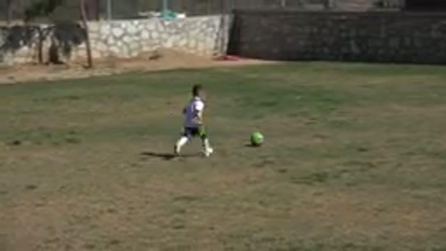 LOS CABOS MEXICO-2019: Kids Playing Soccer In The Grass With Stone Wall