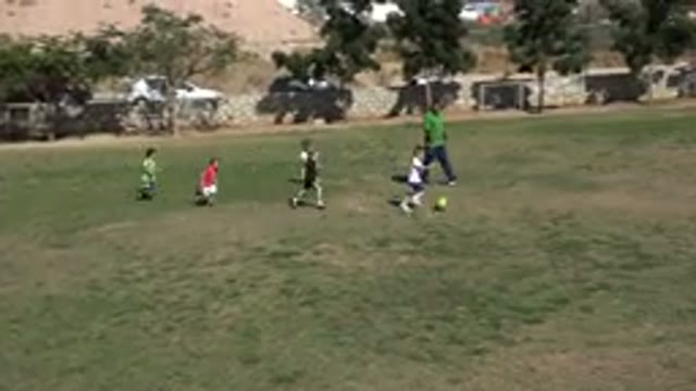 LOS CABOS MEXICO-2019: Children Playing Soccer In A Green Field Surrounded By A Brick Wall