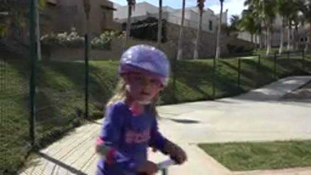 LOS CABOS MEXICO-2019: Girl Wearing Blue Shirt Rides Pink And Black Scooter On A Sunny Day