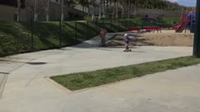 LOS CABOS MEXICO-2019: Kid In A Park Riding A Scooter With An Adult In The Background