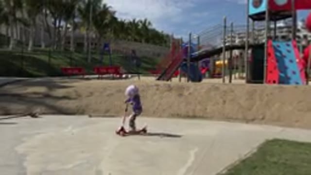 LOS CABOS MEXICO-2019: Little Girl Wearing Purple Rides Scooter Near Pole Protected Area