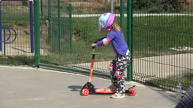 LOS CABOS MEXICO-2019: Little Girl With Purple Helmet Riding Step Bike Outside At Playground