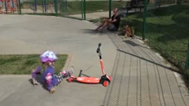 LOS CABOS MEXICO-2019: A Girl Falls Off Her Red Toy Scooter In A Park