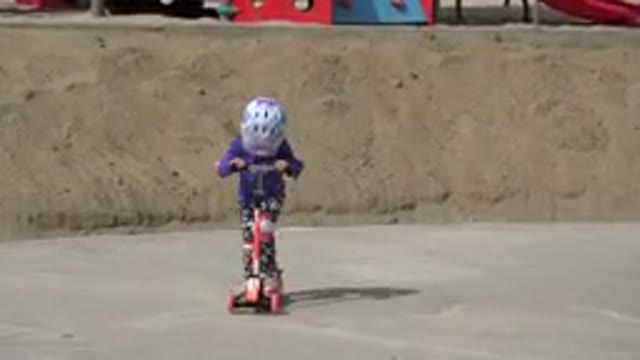LOS CABOS MEXICO-2019: Little Girl in Purple Shirt and Helmet Scooting in Park