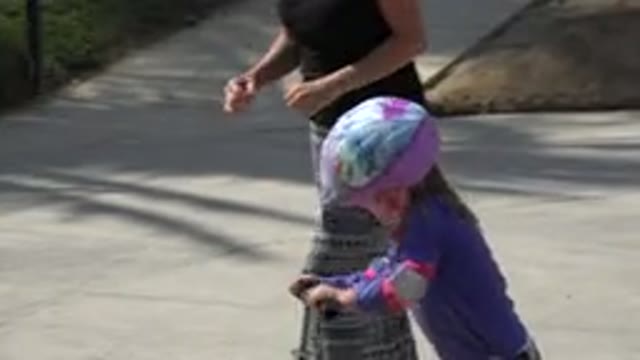 LOS CABOS MEXICO-2019: Little Girl On Scooter Wearing Helmet Races Woman In The Park