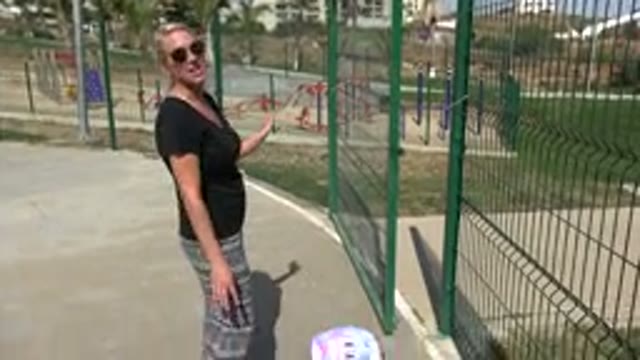 LOS CABOS MEXICO-2019: Woman In Park Near Playground Standing Near Green Fence