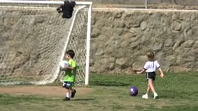 LOS CABOS MEXICO-2019: Boy Wearing Green Shirt Holds White Soccer Ball On A