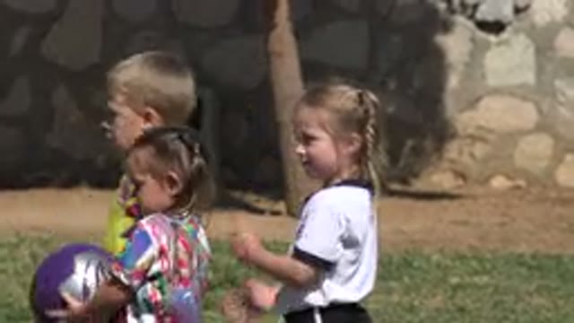 LOS CABOS MEXICO-2019: Three Children In A Field Getting Ready To Play With A Purple Ball