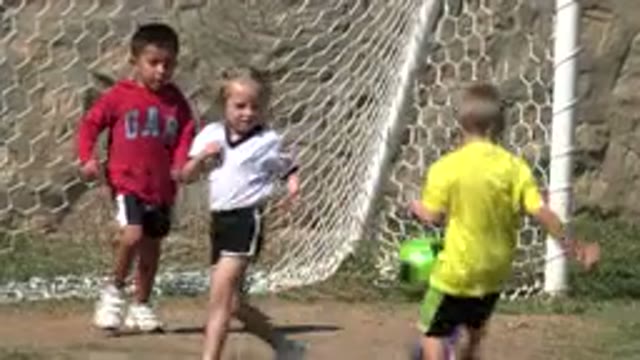LOS CABOS MEXICO-2019: Little Girl Practices Kicking A Soccer Ball With The Boys