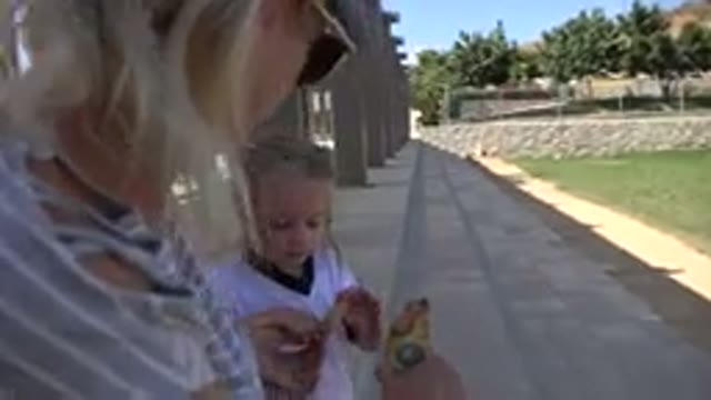 LOS CABOS MEXICO-2019: Child Eating Snack With Mother While Sitting On Steps