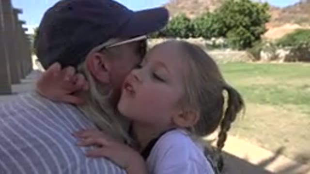 LOS CABOS MEXICO-2019: A Little Girl Chewing Gum Hugs A Woman In Front Of A