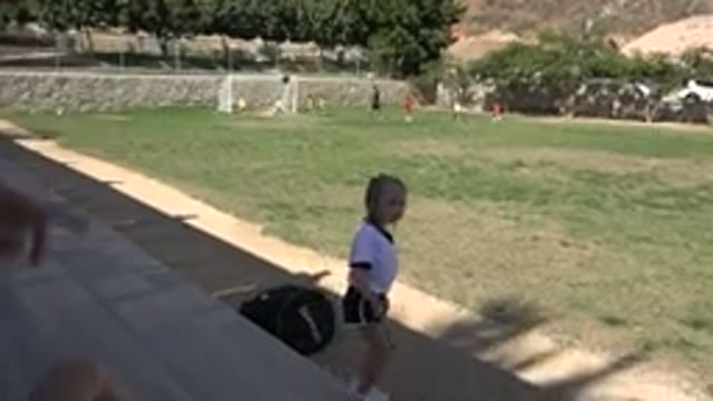 LOS CABOS MEXICO-2019: Girl Wearing White Shirt Walks Down Tan Bleachers On A Sunny Day