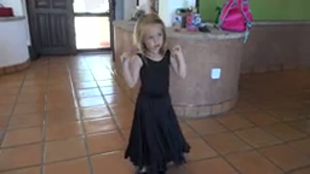 LOS CABOS MEXICO-2019: Blonde Child in Black Dress with Blue Ribbon Playing