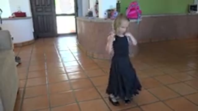 LOS CABOS MEXICO-2019: Little Girl In Black Dress Dances As She Fidgets With Blue Ribbon
