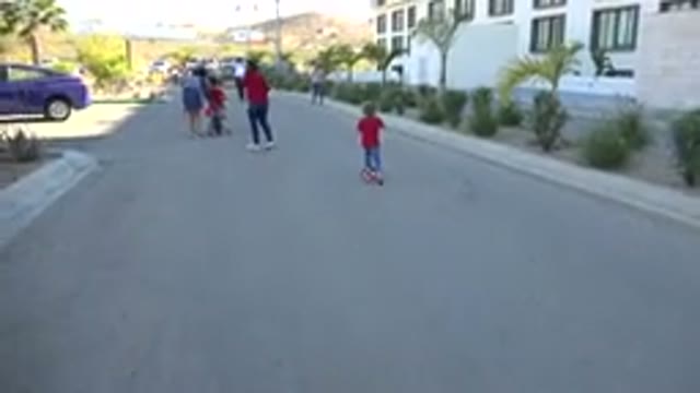 LOS CABOS MEXICO-2019: View Of Child Wearing Red Shirt Riding A Red Scooter On A