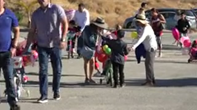 LOS CABOS MEXICO-2019: Children Ride Bikes With Colored Balloons Together With
