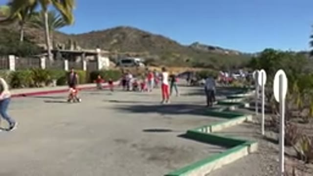 LOS CABOS MEXICO-2019: Neighborhood Parade With Families and Child Falls Down