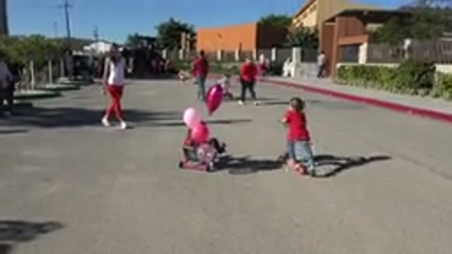 LOS CABOS MEXICO-2019: Children Riding Bikes and Scooters on a Sunny Street