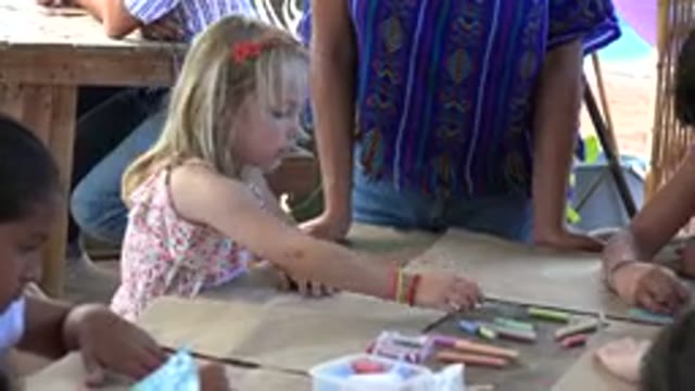 LOS CABOS MEXICO-2019: Young Girl Sitting At A Table With Other Children Selects Colors