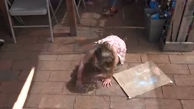 LOS CABOS MEXICO-2019: Child Using Sidewalk Chalk To Express Her Creativity