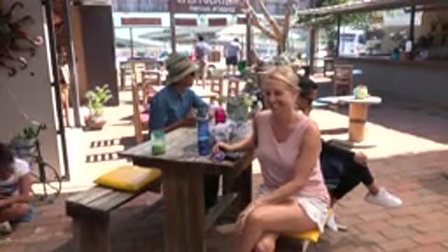LOS CABOS MEXICO-2019: Nice Lady At A Table With Legs Crossed Tells Videographer