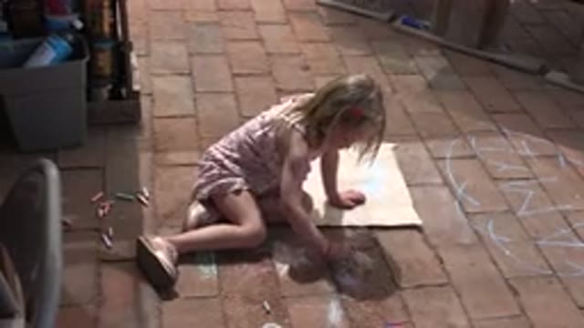 LOS CABOS MEXICO-2019: Little Girl Sitting In The Sun On Brick Drawing With Chalk