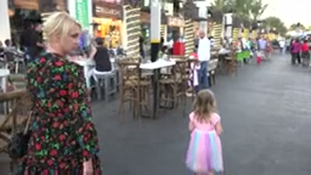 LOS CABOS MEXICO-2019: Woman Wearing Black And Red Dress Follows Girl Wearing Pink