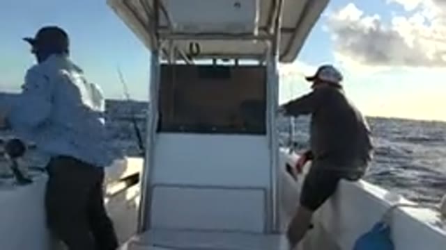 LOS CABOS MEXICO-2019: Three Men Fish In A Boat That Is Rocking And Reeling