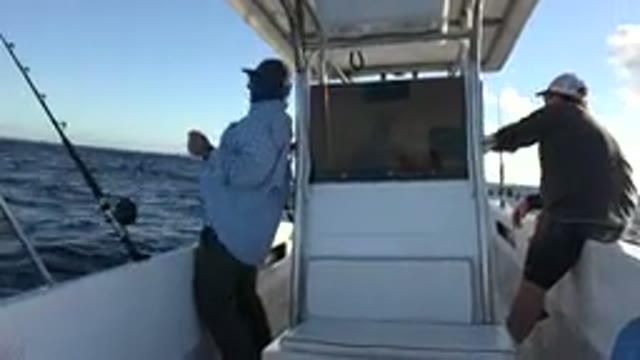LOS CABOS MEXICO-2019: Two Men Wearing Caps Fishing On A Shaking Boat