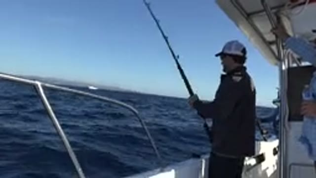 LOS CABOS MEXICO-2019: Man On Boat Fishing Offshore Near Land In Slightly Rough Sea