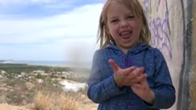 LOS CABOS MEXICO-2019: Little Girl Playing With A Bracelet On A Hilltop Excited