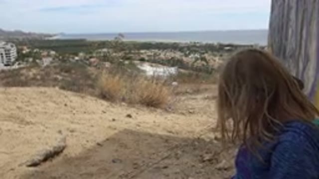 LOS CABOS MEXICO-2019: Young Girl Watching Her Dog Explore While On A Hiking