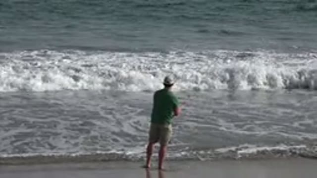LOS CABOS MEXICO-2019: Man Standing At Waterline On The Beach Fishing As The Waves Roll In