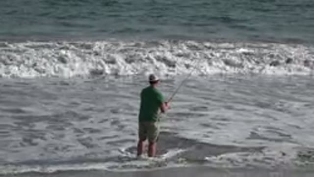 LOS CABOS MEXICO-2019: A Man Standing On The Beach In The Surf Fishing