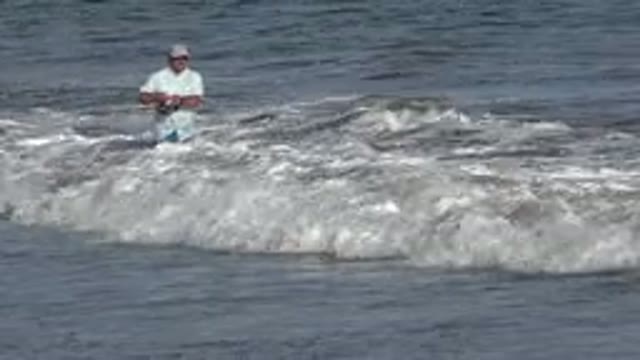 LOS CABOS MEXICO-2019: Adult Man Fully Dressed Shaking Fishing on Road Among Waves