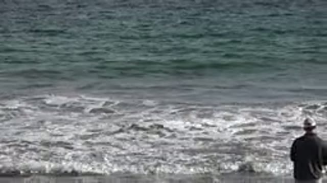 LOS CABOS MEXICO-2019: Man Wearing Hat And Shorts Fishing On A Beach