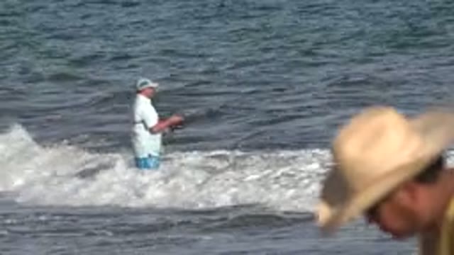 LOS CABOS MEXICO-2019: Man Fishing On The Shore And Getting Soaked From A Wave