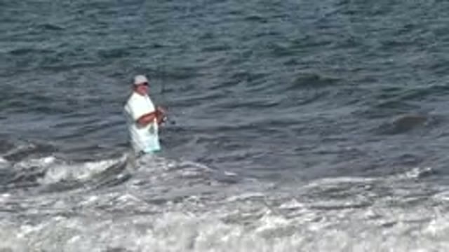 LOS CABOS MEXICO-2019: A Middle Aged White Man Fishes Waist Deep In Water
