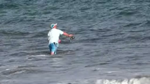 LOS CABOS MEXICO-2019: Fisherman Wading In Shallow Waters Trying To Haul In His Catch