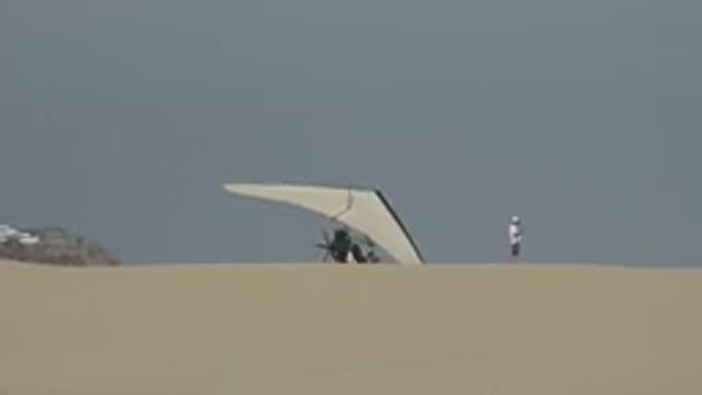 LOS CABOS MEXICO-2019: A Man Standing In Front Of A Hang-Glider In The Desert