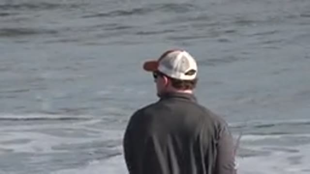 LOS CABOS MEXICO-2019: Fisherman Reels In His Rod As Waves Crash Onto the Beach