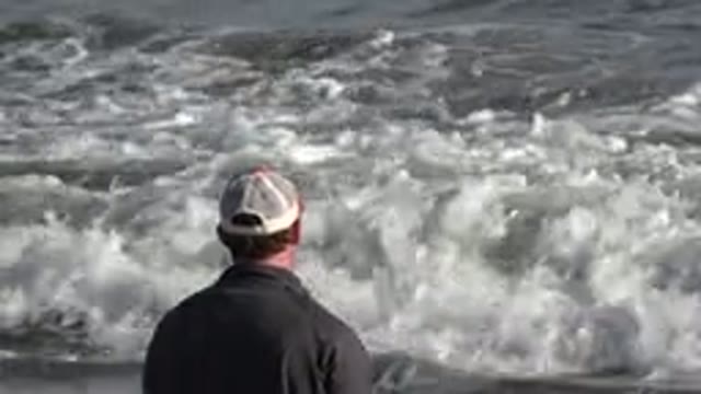 LOS CABOS MEXICO-2019: Man With A Hat Stares At The Sea As A Small Wave Approaches