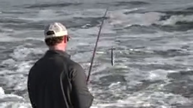 LOS CABOS MEXICO-2019: An Adult Man In A Shirt Fishing For Small Fish In The Sea
