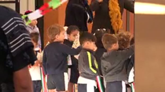SAN JOSE DEL CABO MEXICO-2019: Clumsy Child Holding A Flag Among Friends At School Event