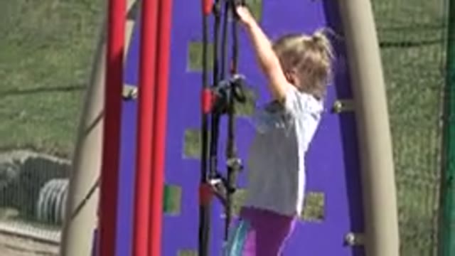 SAN JOSE DEL CABO MEXICO-2019: Little Girl Climbing Park Fence Outside Playground