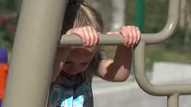 SAN JOSE DEL CABO MEXICO-2019: Little Girl With Blond Hair Climbing The Monkey Bars