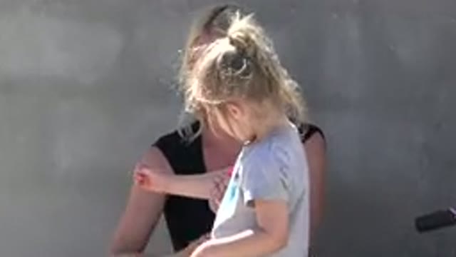 SAN JOSE DEL CABO MEXICO-2019: Woman Helps Little Girl Put On Elbow Pads